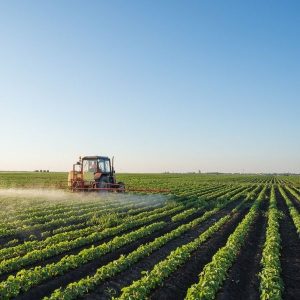 African farmer applying liquid NPK fertilizer through drip irrigation for improved crop growth and higher yields.